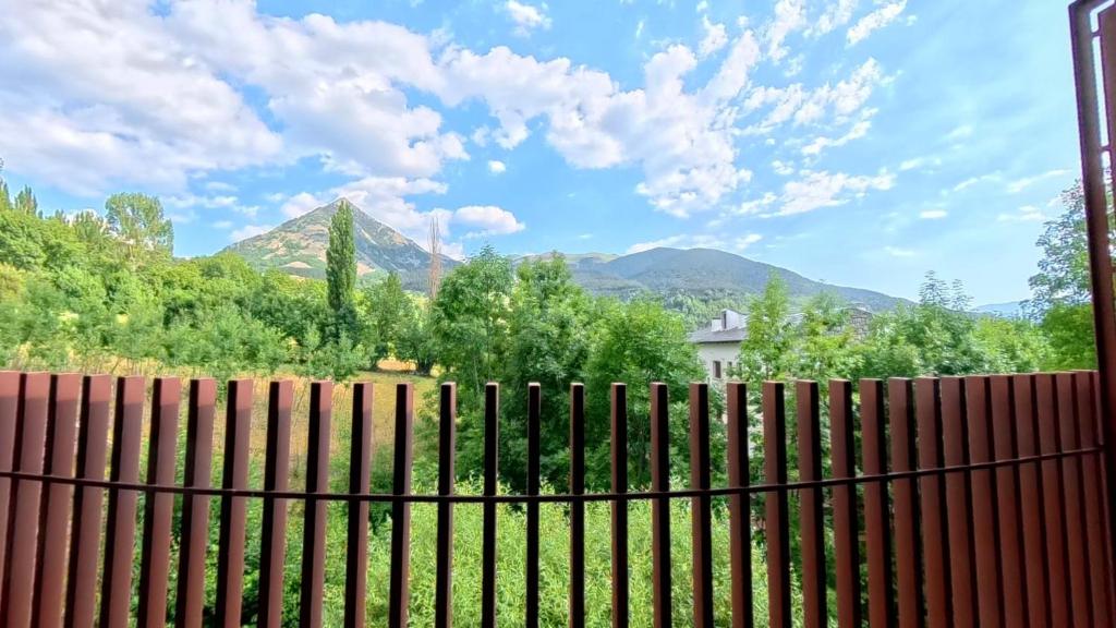 a fence with mountains in the background at Las casitas de mache - LAGOSSA in Cerler