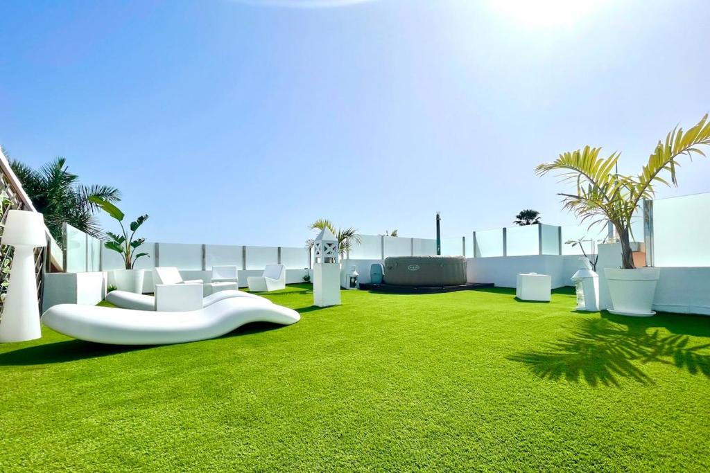 a green lawn with white furniture on top of a building at Oasis Penthouse Maspalomas in Maspalomas