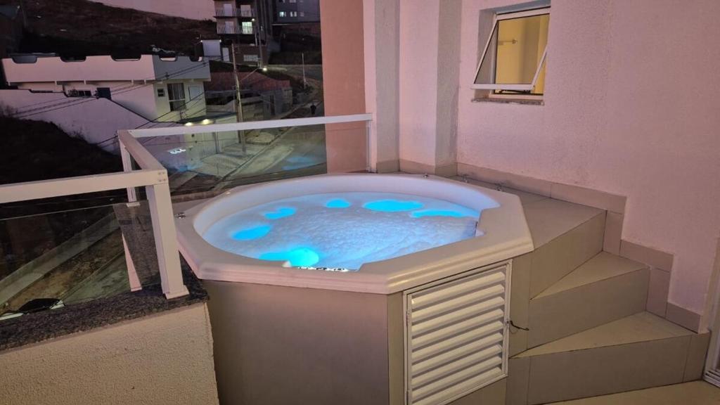 a hot tub in the corner of a building at Charmoso Duplex com Jacuzzi in Poços de Caldas