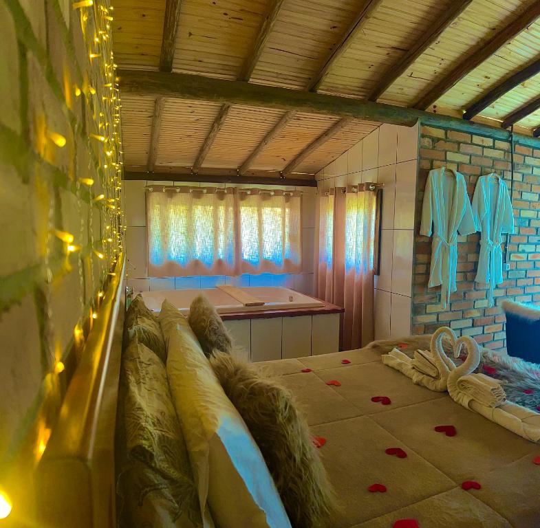 Quiosque Família Chalé Garça في جوانوبوليس: غرفة نوم بها سرير وحوض استحمام في الغرفة