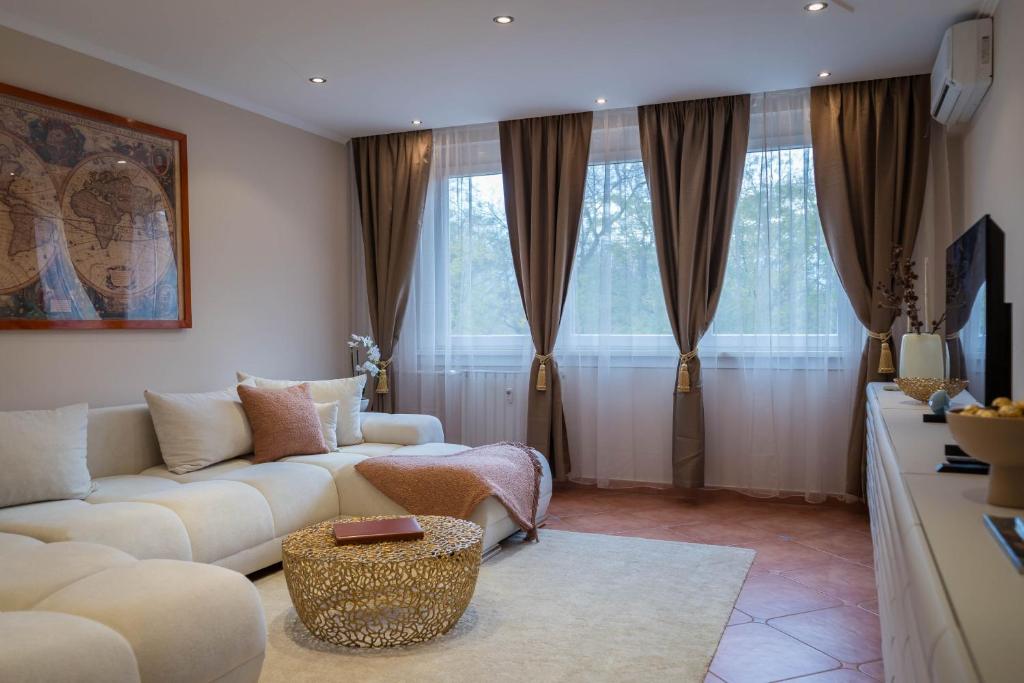 The GOR Apartment في كيسكيميت: غرفة معيشة مع أريكة بيضاء وبعض النوافذ