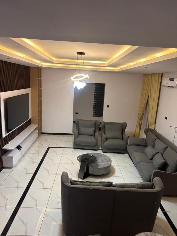 een woonkamer met een bank en een tv bij Next Level Apartments and Suites in Ibadan