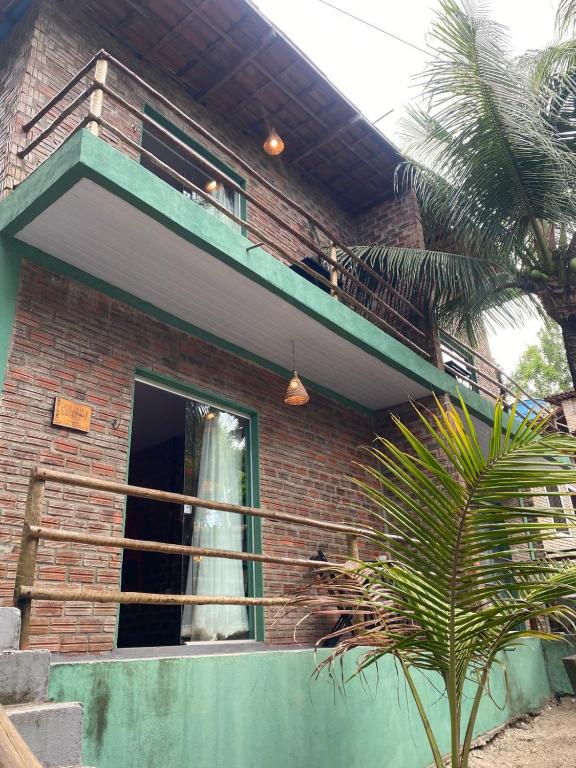 a cat sitting on the balcony of a house at MOVE quartos de hotel in Pipa
