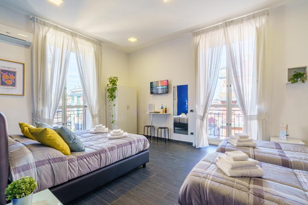 a bedroom with two beds and a large window at Calaba SpaccaNapoli in Naples