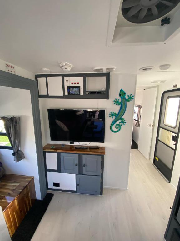 sala de estar con TV y pared en Clamping Caravan, en Whanganui