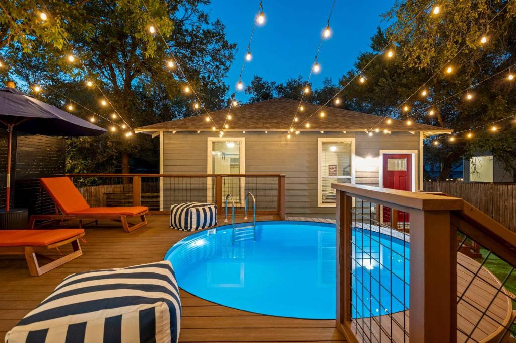 een terras met een zwembad en lichtslingers bij The Backyard Collective 6BR 2 Homes Pool & More in Austin