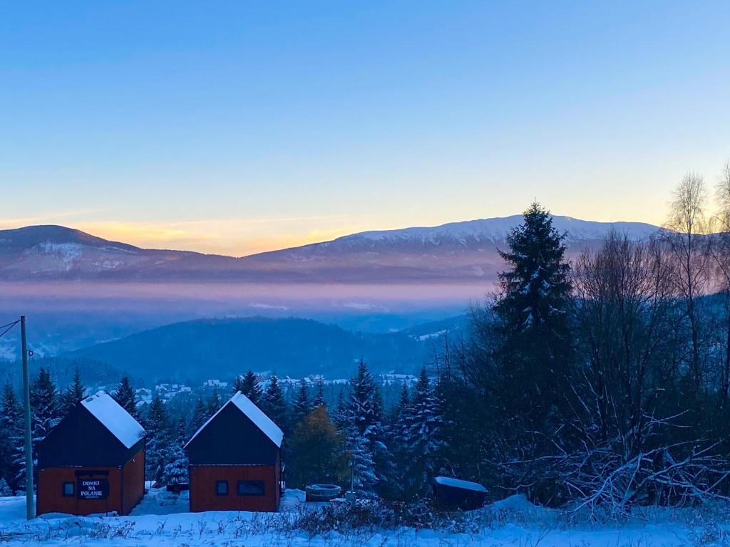 a couple of barns in the snow at sunset at Domki na polanie in Stryszawa