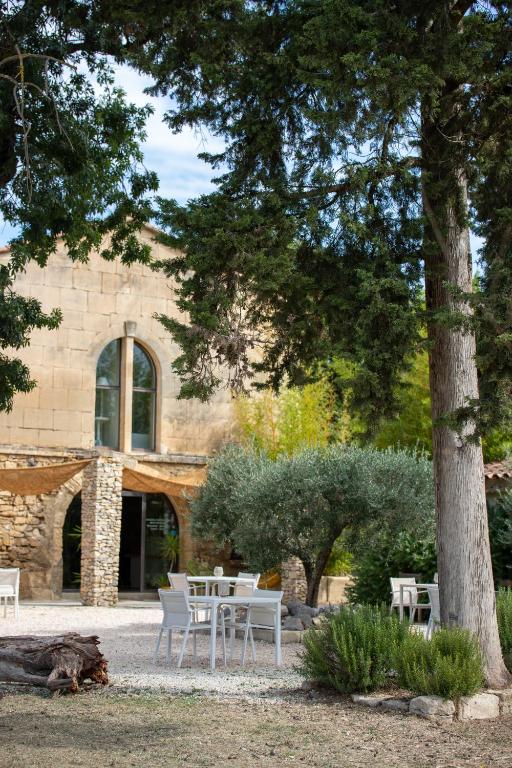 a table and chairs in front of a building at Le Mas d'Eymard in Arles