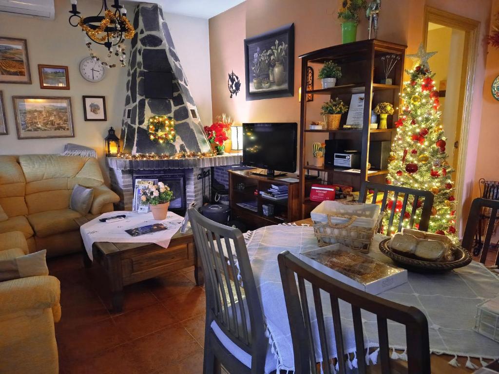 a living room with a christmas tree and a table at Casa Rural Dani Escalona in Toledo