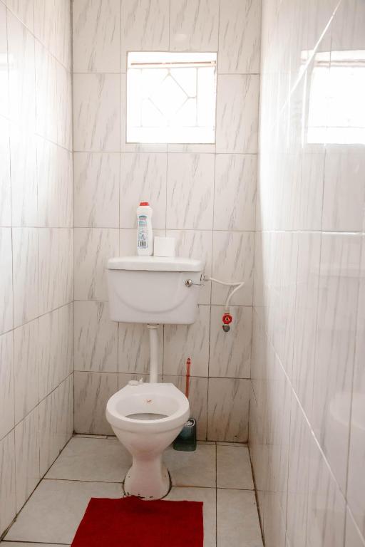 łazienka z białą toaletą i oknem w obiekcie Collins apartment w Ndola