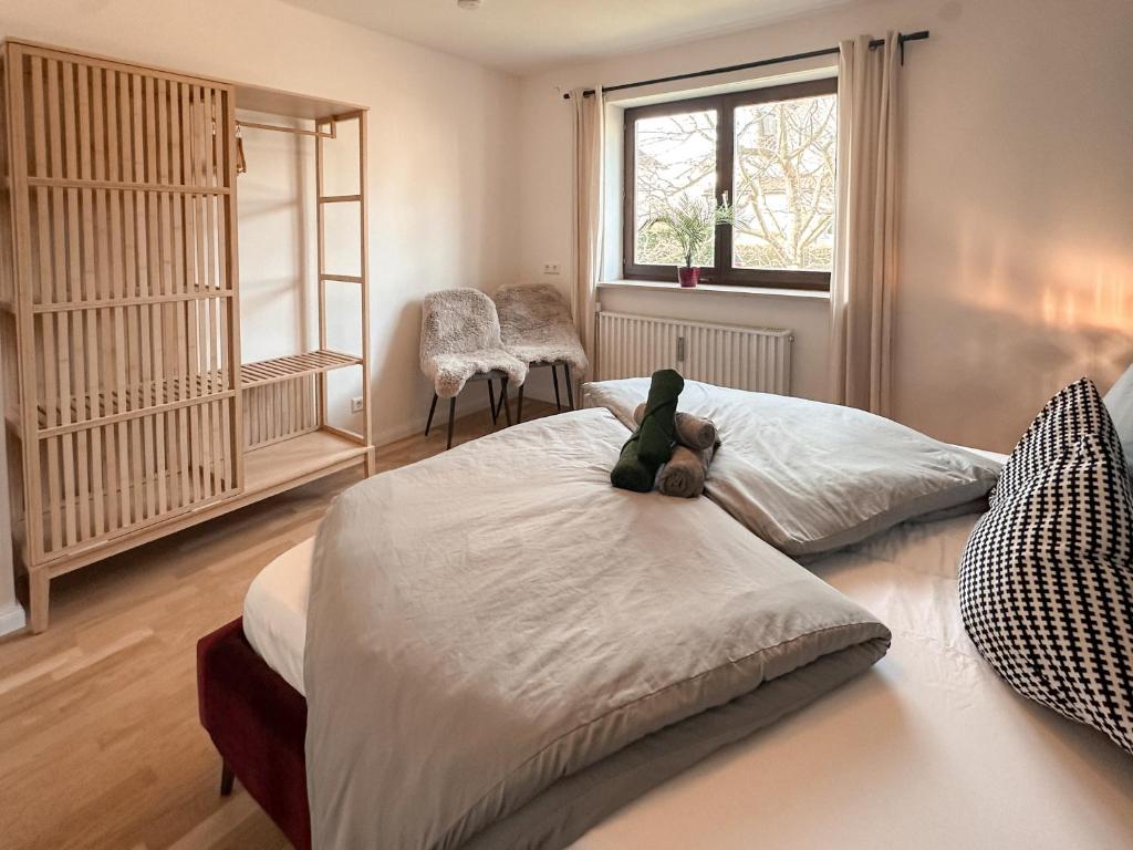 un orsacchiotto seduto su un letto in una camera da letto di Allgäu Retreat a Bad Wörishofen