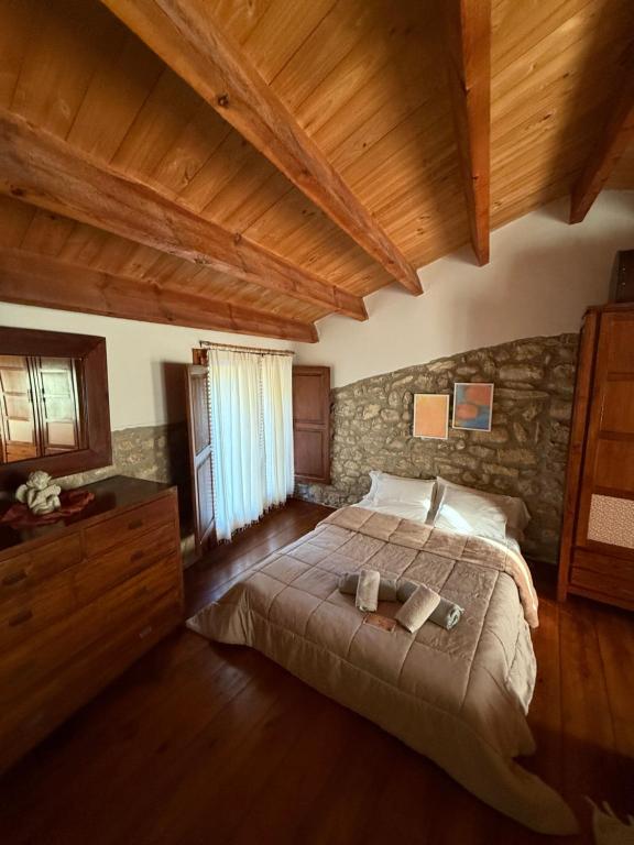 Can L'Hospitalet في Sant Ferriol: غرفة نوم بسرير وجدار حجري