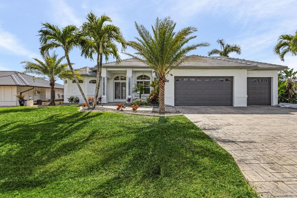 a house with palm trees in the yard at Coastal River Oasis in Cape Coral