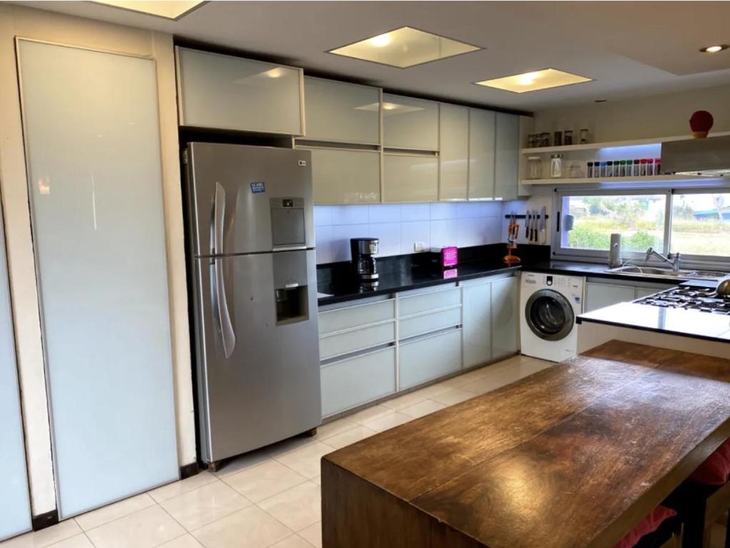 a kitchen with a stainless steel refrigerator and a table at Ostende frente al mar in Ostende