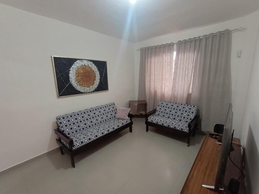 a living room with two chairs and a window at Aconchego em Bertioga in Bertioga