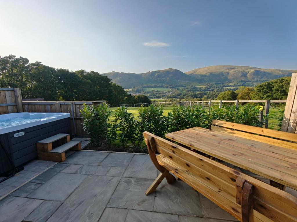 TillicoultryにあるDevonknowes lodgesの温水浴槽のあるデッキに置かれた木製のベンチ