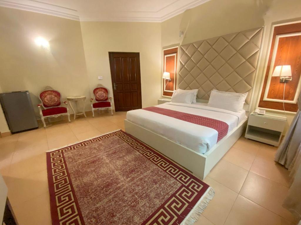 a bedroom with a large bed and a rug at Margalla Residency Islamabad in Islamabad