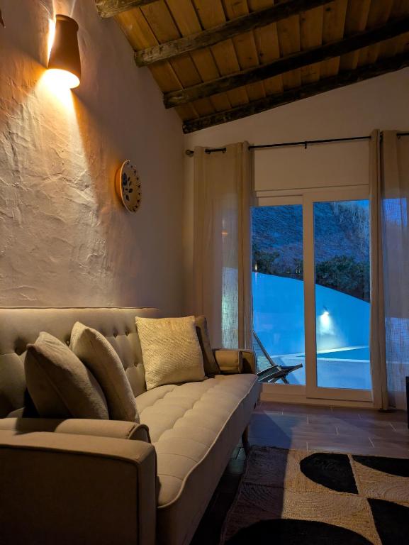 a living room with a couch and a large window at Casas da Lola - Mourão in Mourão