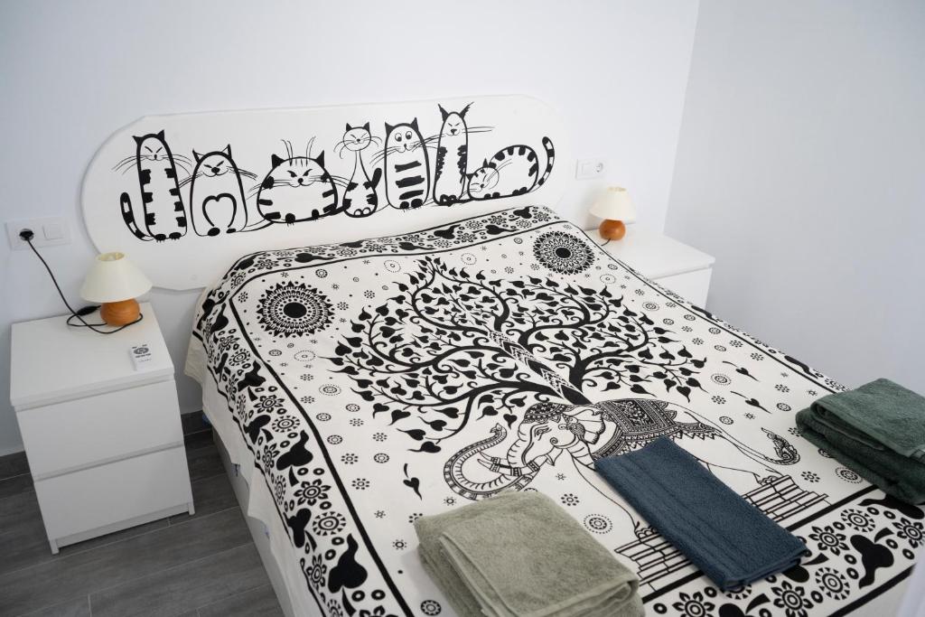 un letto con un copriletto bianco e nero con un albero sopra di Siempre, Siempre el SOL a Mojácar