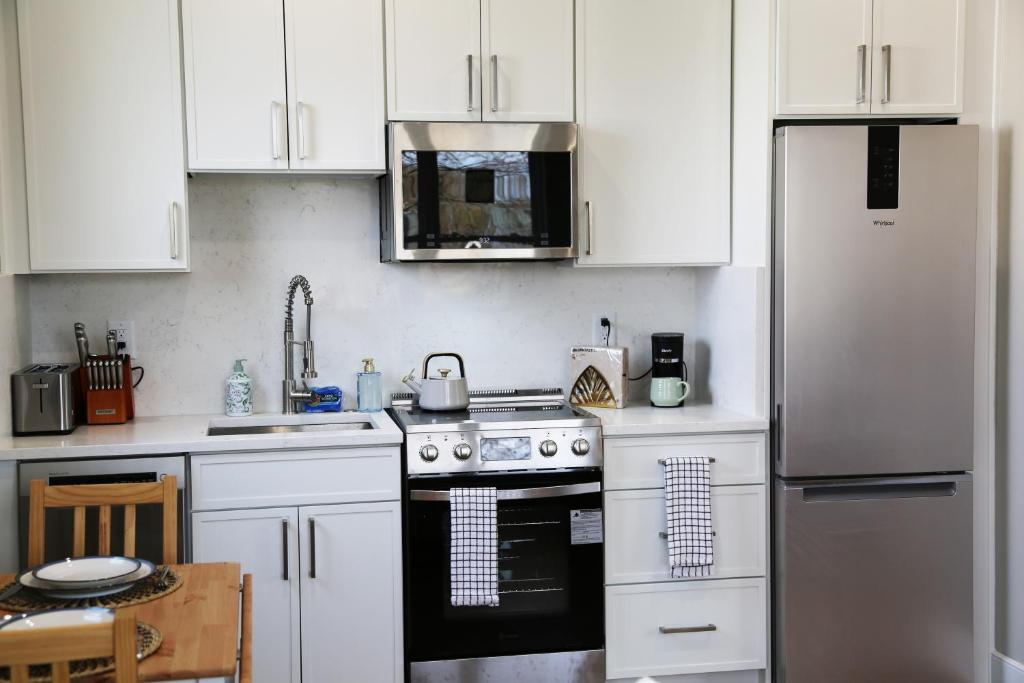 a white kitchen with a stove and a refrigerator at Charming Carriage House in NE Washington DC in Washington