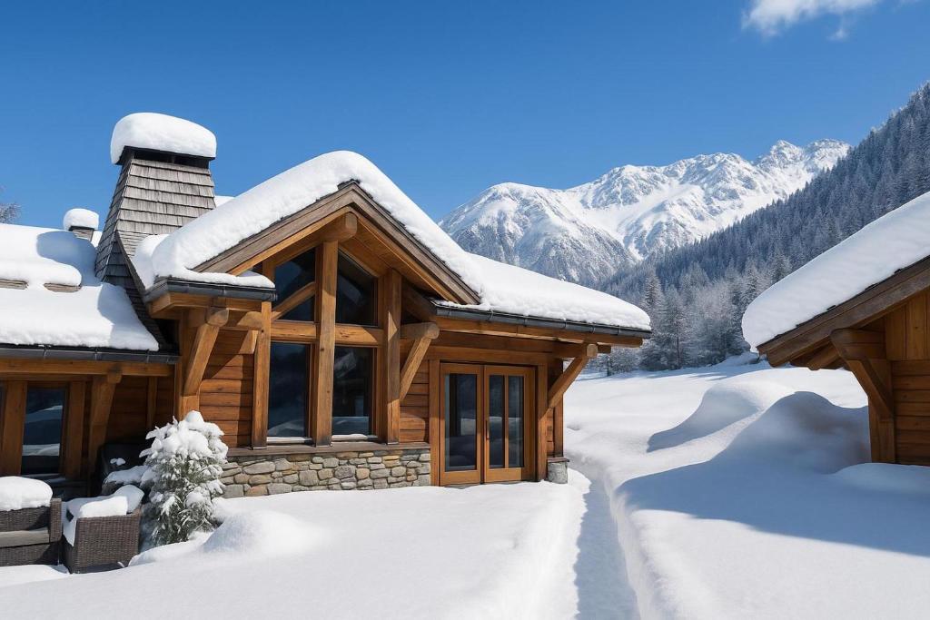 een hut bedekt met sneeuw met bergen op de achtergrond bij Chalets d'en haut - Bonheur - Happy Rentals in Chamonix-Mont-Blanc