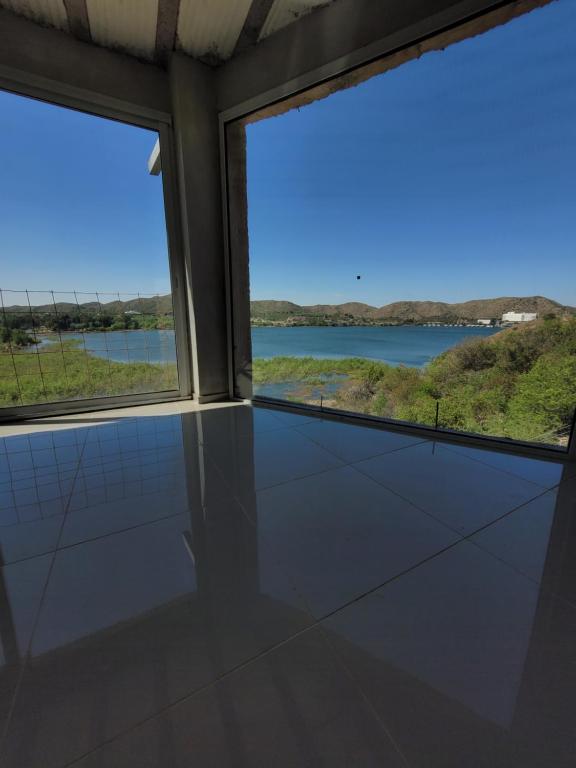 a room with two windows and a view of a river at Punta El Tesoro - Playa Privada al Lago in Potrero de los Funes