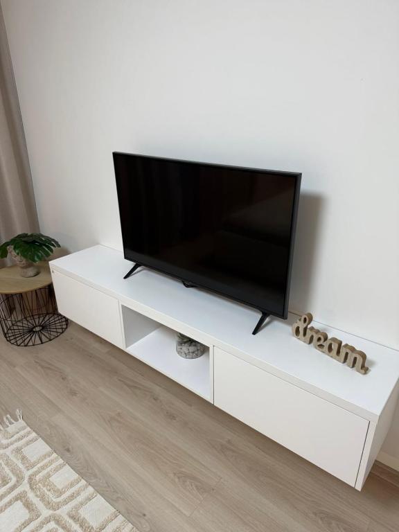a white entertainment center with a flat screen tv on it at Compleks by Karlus in Jelgava