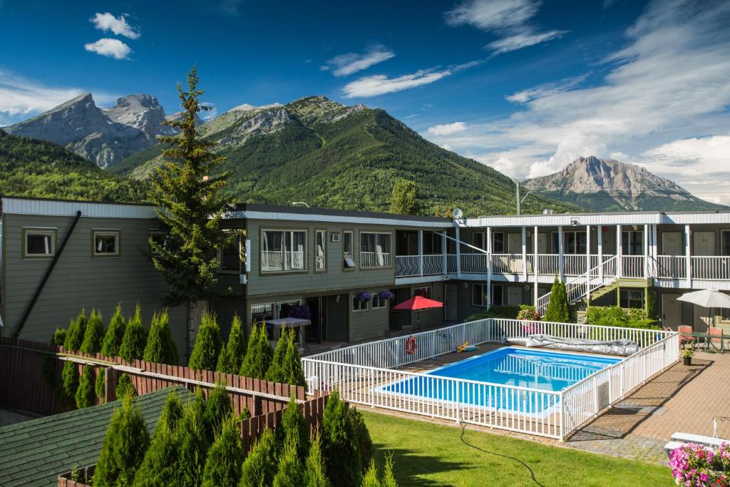 a resort with a pool and mountains in the background at Powder Mountain Lodge in Fernie