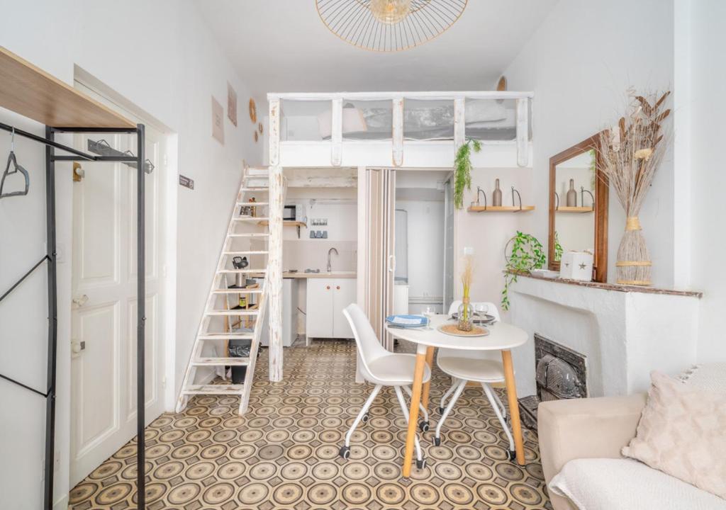 Studio mezzanine cosy au centre Beaucaire - Cocon 2 في بوكير: غرفة معيشة صغيرة مع طاولة وسرير