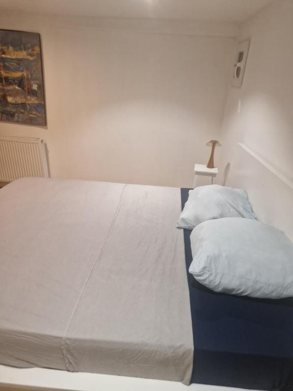 Chambre ouverte colloc - Bordeaux centre في بوردو: غرفة نوم بسرير كبير مع ملاءات بيضاء