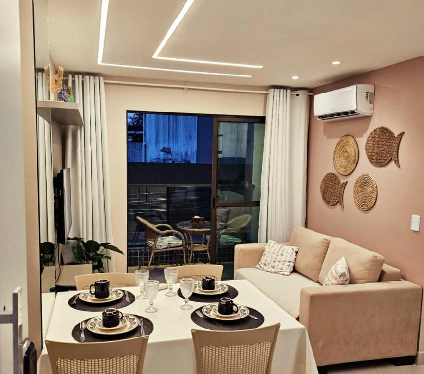 Flat charmoso no Centro de Porto de Galinhas في بورتو دي غالينهاس: غرفة معيشة بها طاولة وأريكة