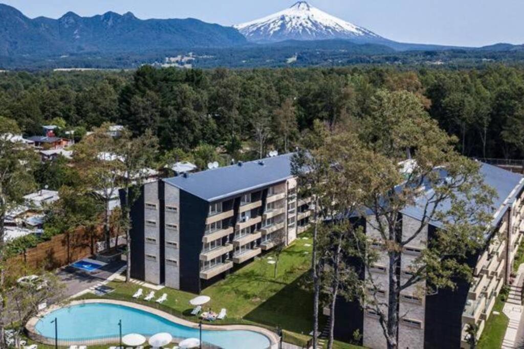 Una vista aérea de un hotel con una montaña al fondo. en Entorno Natural, cerca del centro de Pucón Parking Privado, en Pucón