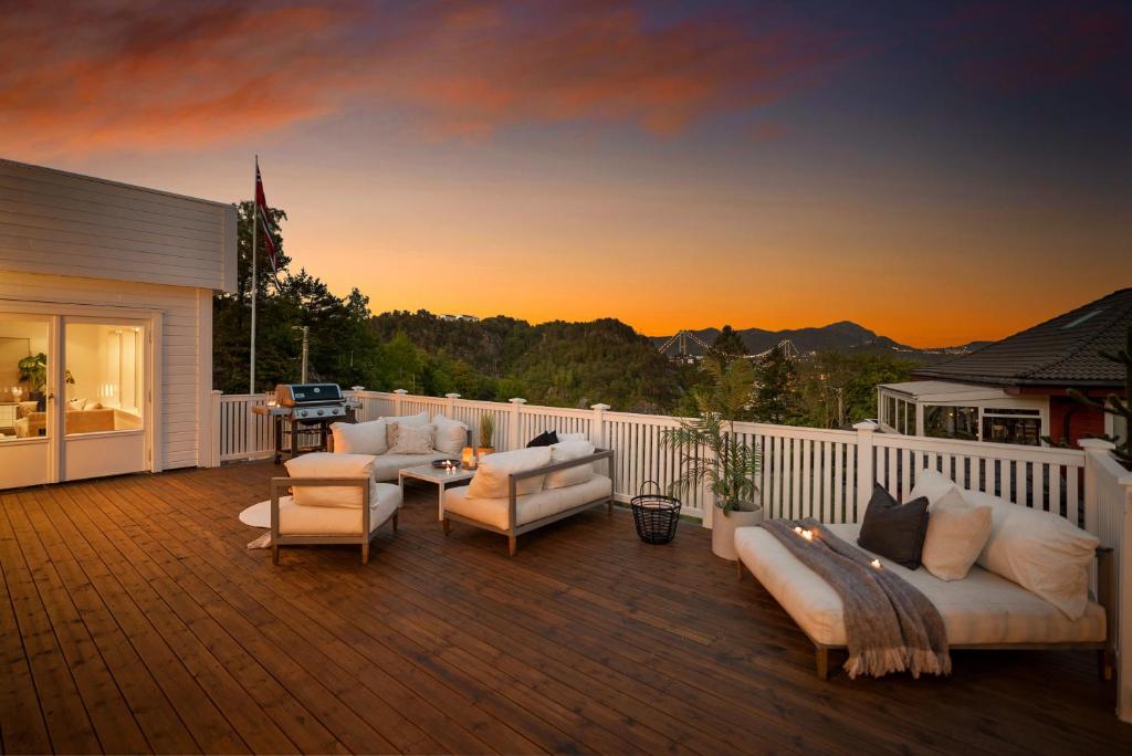 Un patio con sofás y sillas en una terraza. en Spacious Group Villa with Jacuzzi and Views, en Askøy