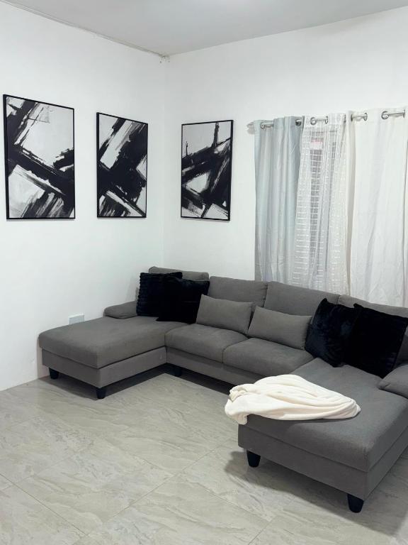 a living room with a couch and pictures on the wall at Angella Mansions in Stony Hill