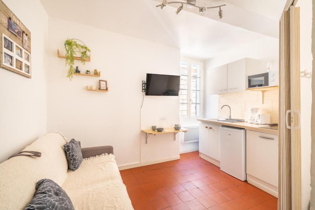 a living room with a couch and a kitchen at Studio cosy et lumineux Centre de Beaucaire - cocon 3 in Beaucaire