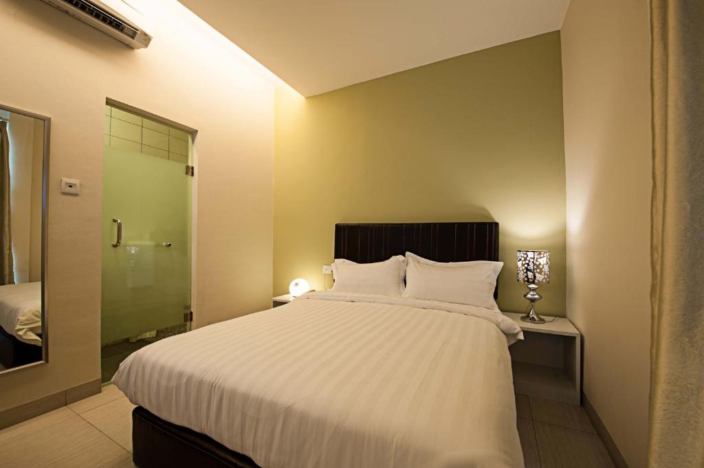 a bedroom with a large white bed and a bathroom at Seven Hotel in Putatan