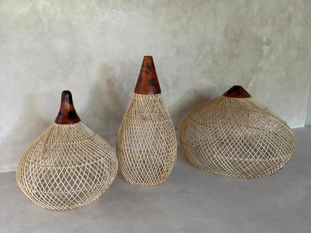 クタにあるZENARA lombokの壁の横に置かれた3つの装飾花瓶
