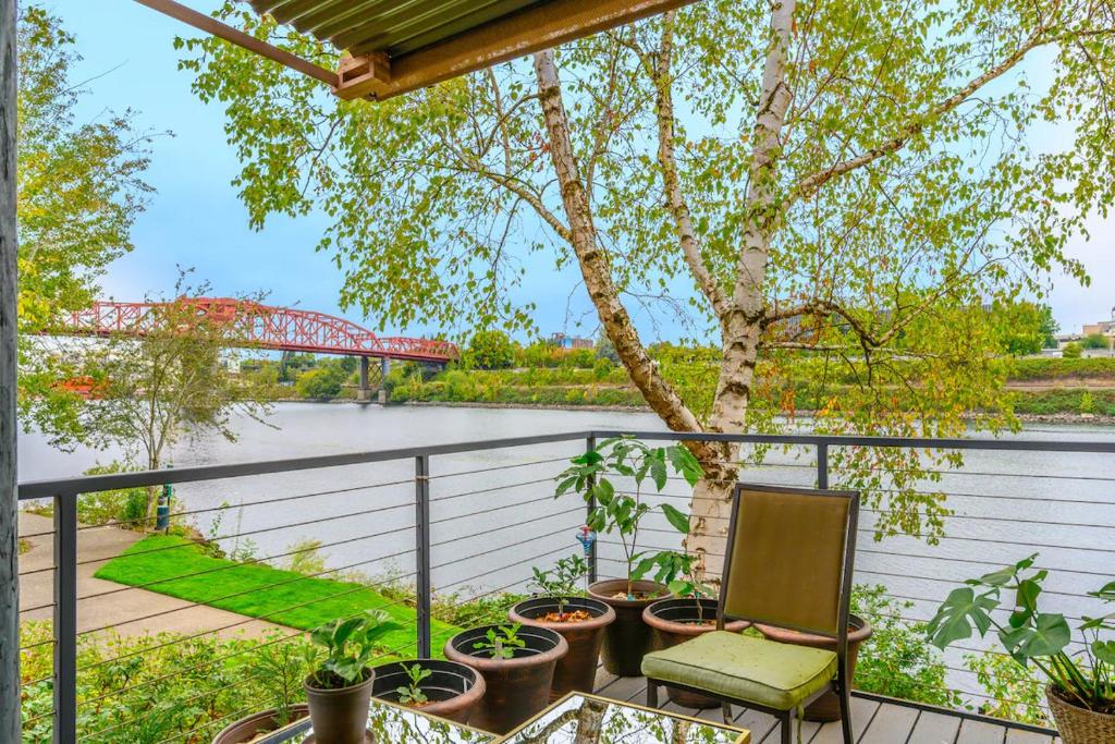 uma varanda com plantas e vista para um rio em Waterfront Condo, 25ft from riverwalk, Pool & HotTub em Portland