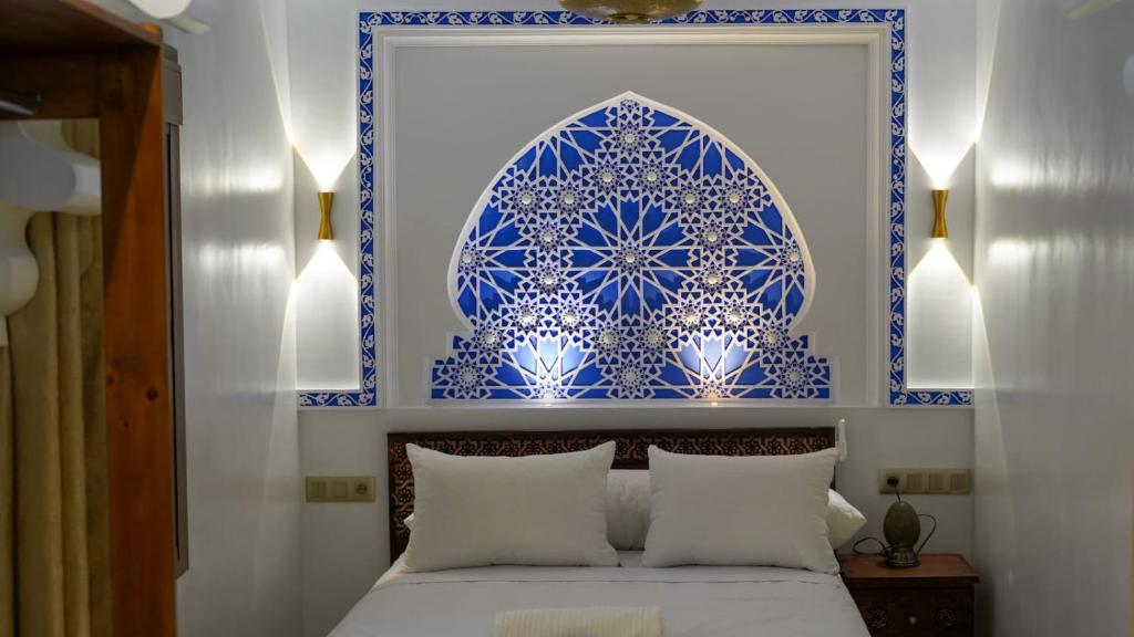 a bedroom with a blue and white wall at Dar Ouadie the pearl stay in Chefchaouen