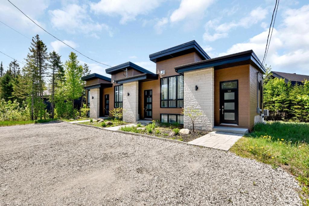 a house with a driveway in front of it at Agora Trio Portneuf - 3 Family Units - Spa & Nature in Pont-Rouge