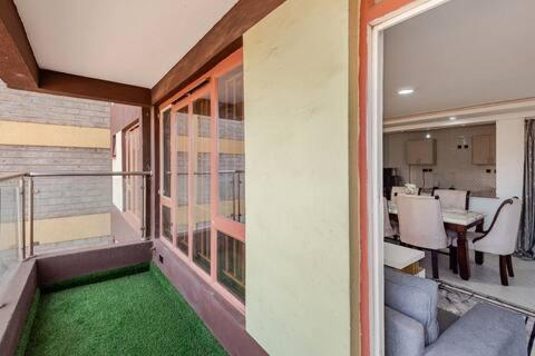 a balcony with green flooring and a table and chairs at 2bedroom house along waiyaki way in Nairobi