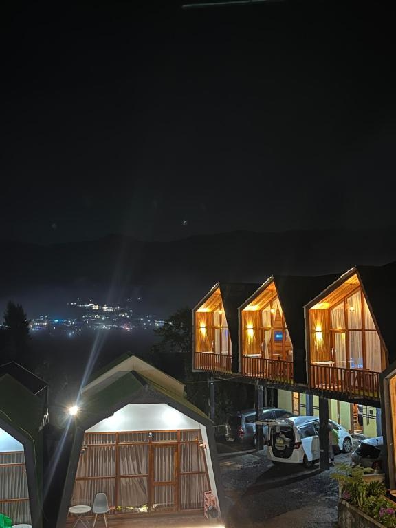 a group of houses at night with lights at Cabin Hillside Dieng in Diyeng