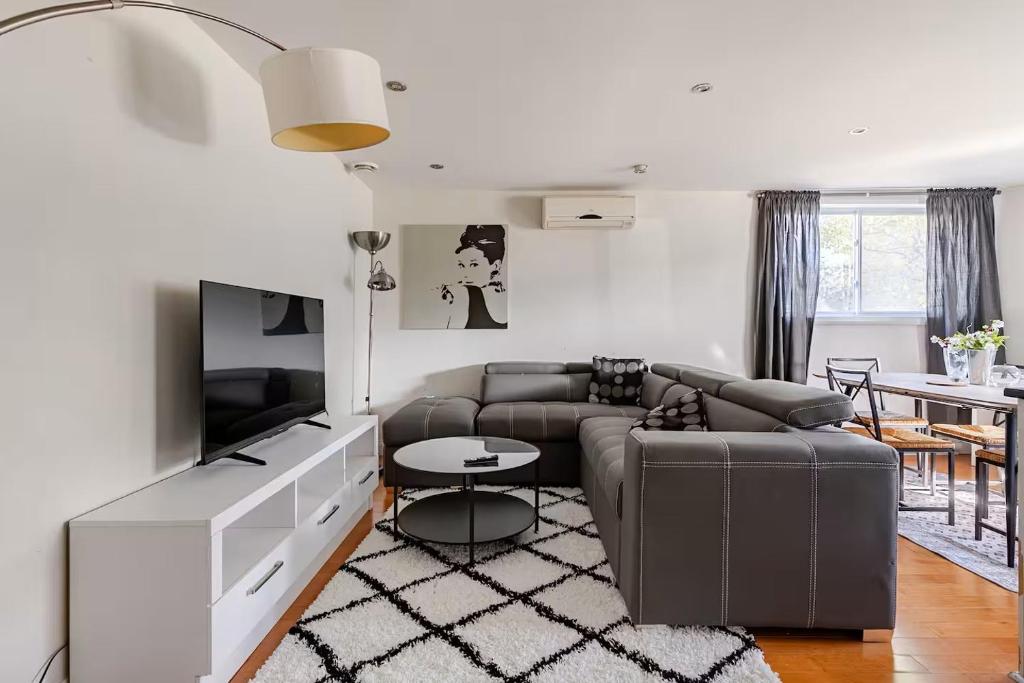 a living room with a couch and a tv at Voltaire 1 Apartement 4,5 2ch Laval, Canada in Laval