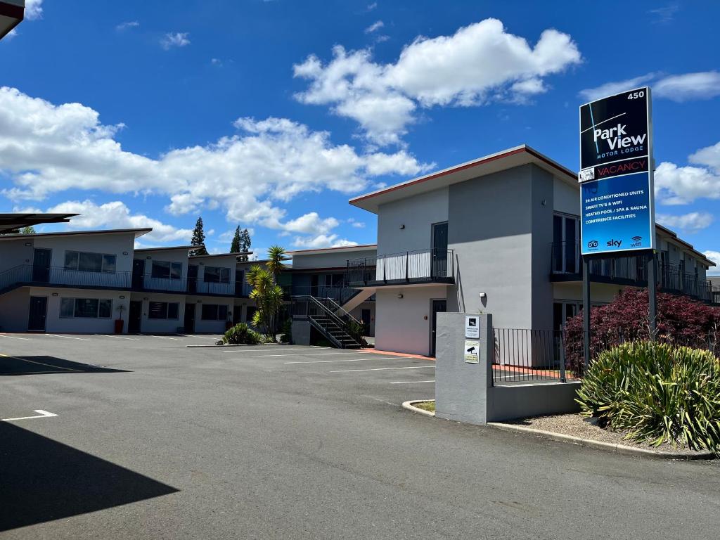 a parking lot with a sign in front of a motel at Park View Motor Lodge in Hamilton
