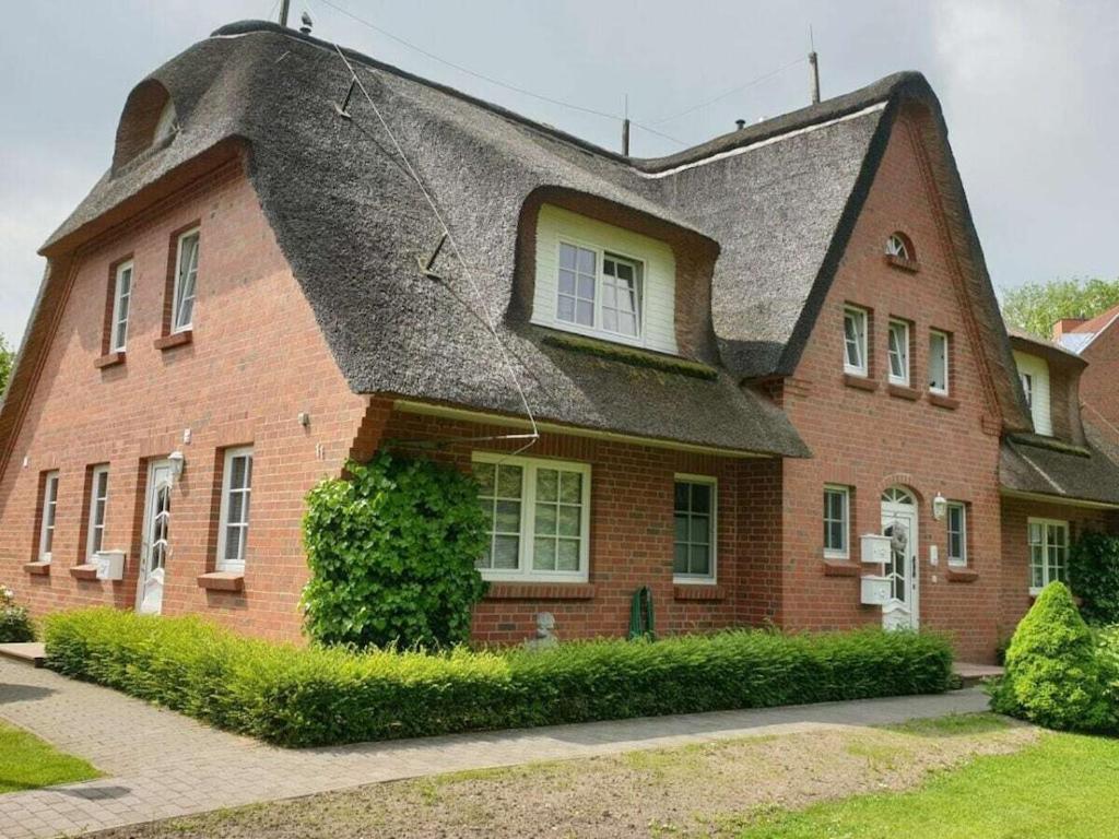 a large red brick house with a gray roof at Refugium 54° Timmendorfer Strand in Timmendorfer Strand