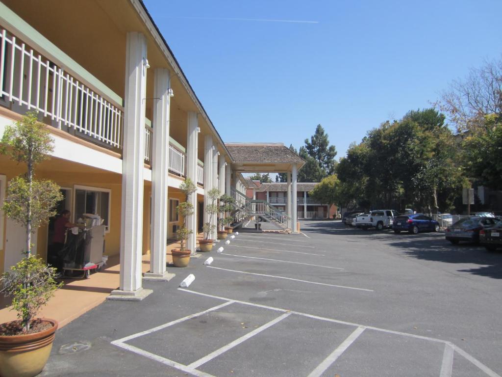 un parcheggio vuoto di fronte a un edificio di Caravelle Inn Extended Stay a San Jose