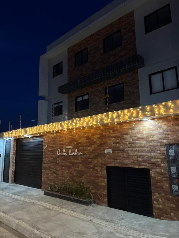a brick building with garages and lights on it at Apto 2 Quartos Novo e Super Confortável in Arapiraca
