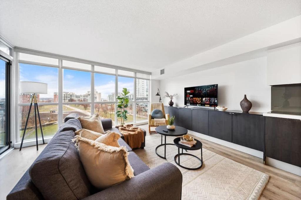 a living room with a couch and a tv at Spacious Downtown Condo - Walk to CN Tower & More in Toronto