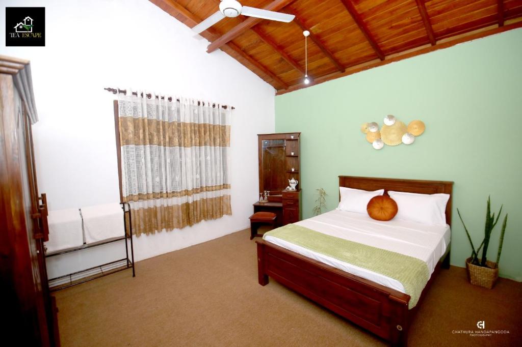 a bedroom with a bed in a room with a window at Tea Escape Holiday Villa and Cabanas in Gampola