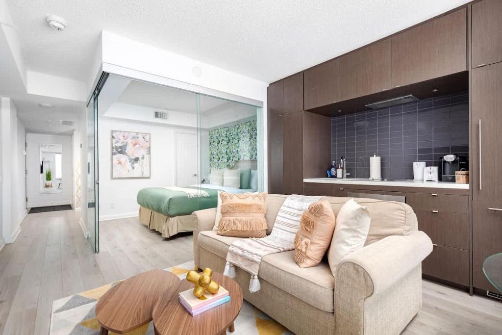 a living room with a couch and a bedroom at Plush Yorkville Designer Condo with Glam Suite in Toronto